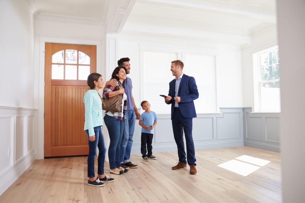 family of four discus FHA financing options with their real estate agent as they tour a home
