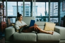 Woman working on laptop on the couch in her apartment